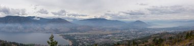 Bulutlu ve dumanlı bir yaz sabahı Penticton City panoramik görünümü. Alınan Skaha Bluffs Provincial Park, British Columbia, Kanada.