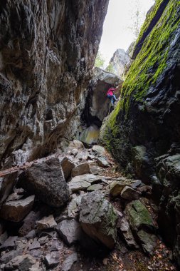 Maceracı kız kayalık bir mağaraya iniyor. Skaha Bluffs İl Parkı, Penticton, British Columbia, Kanada.