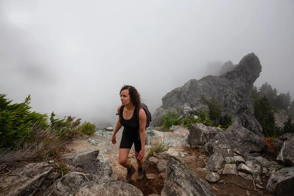 Maceracı Kız bulutlu bir yaz sabahı boyunca güzel bir kayalık dağ kadar dik bir iz kadar yürüyüş olduğunu. Crown Mountain'da çekilmiş, Kuzey Vancouver, Bc, Kanada.