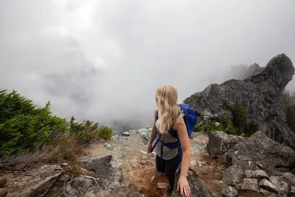 Maceracı Kız bulutlu bir yaz sabahı boyunca güzel bir kayalık dağ kadar dik bir iz kadar yürüyüş olduğunu. Crown Mountain'da çekilmiş, Kuzey Vancouver, Bc, Kanada.