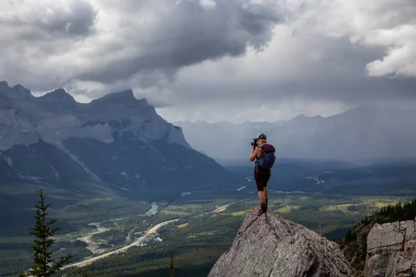 曇りと雨の日に岩山の上で写真を撮る冒険的な女の子 マウントレディマクドナルドから撮影 カンモア アルバータ州 カナダ — ストック写真
