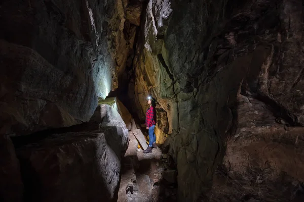 Maceracı kız Skaha Bluffs Provincial Park, Penticton, British Columbia, Kanada doğal bir mağaranın içinde keşfediyor.