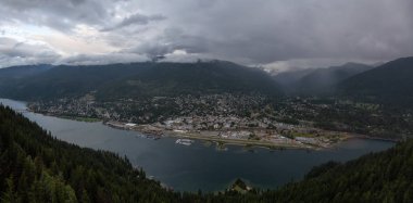 Karanlık ve bulutlu bir gün batımı sırasında küçük bir kasaba, Nelson, güzel Panoramik Görünümü. British Columbia, Kanada'nın iç bölgesinde yer almaktadır..