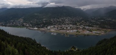 Karanlık ve bulutlu bir gün batımı sırasında küçük bir kasaba, Nelson, güzel Panoramik Görünümü. British Columbia, Kanada'nın iç bölgesinde yer almaktadır..