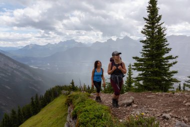 Maceracı Kız bulutlu ve yağmurlu bir gün boyunca kayalık bir dağkadar yürüyüş olduğunu. Lady Macdonald, Canmore, Alberta, Kanada'dan alındı.