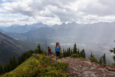 Maceracı Kız bulutlu ve yağmurlu bir gün boyunca kayalık bir dağkadar yürüyüş olduğunu. Lady Macdonald, Canmore, Alberta, Kanada'dan alındı.