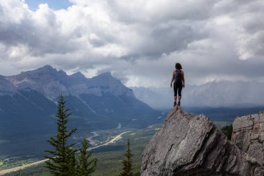Maceracı Kafkas Kız bulutlu ve yağmurlu bir gün boyunca kayalık bir dağa kadar yürüyüş olduğunu. Lady Macdonald, Canmore, Alberta, Kanada'dan alındı.