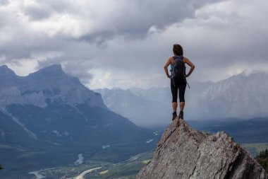 Maceracı Kafkas Kız bulutlu ve yağmurlu bir gün boyunca kayalık bir dağa kadar yürüyüş olduğunu. Lady Macdonald, Canmore, Alberta, Kanada'dan alındı.