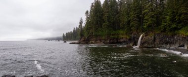 Sisli ve yağmurlu bir yaz gününde Juan de Fuca Trail şelale ile kayalık bir sahil güzel Panoramik Görünümü. Sombrio Beach'te, Port Renfrew yakınlarında, Vancouver Adası, Bc, Kanada.