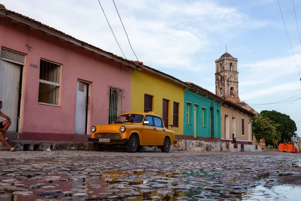 トリニダード キューバ 2019年6月12日 活気に満ちた日当たりの良い夕日の間に教会を背景にした小さなキューバの町の通りで古い古典的なタクシーの車の眺め — ストック写真