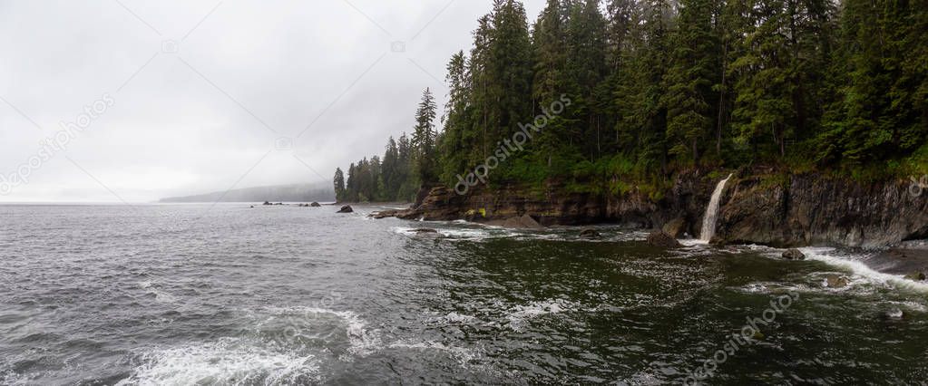 Beautiful Panoramic View of a rocky coast with waterfall on the Juan de Fuca Trail during a foggy and rainy summer day. Taken at Sombrio Beach, near Port Renfrew, Vancouver Island, BC, Canada.