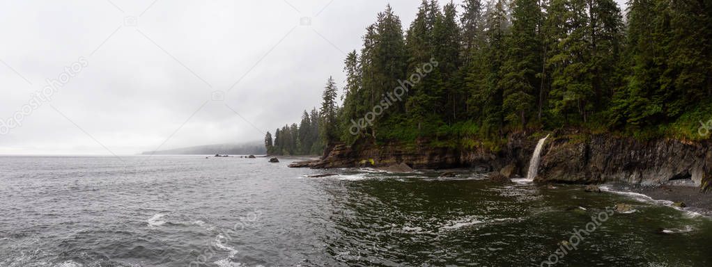 Beautiful Panoramic View of a rocky coast with waterfall on the Juan de Fuca Trail during a foggy and rainy summer day. Taken at Sombrio Beach, near Port Renfrew, Vancouver Island, BC, Canada.