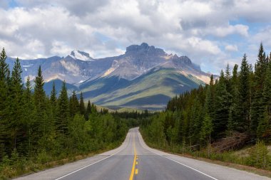 Scenic Empty road in the Canadian Rockies during a vibrant sunny and cloudy summer morning. Taken in Icefields Parkway, Banff National Park, Alberta, Canada. clipart