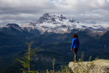 Uçurumun kenarındaki maceraperest kız Sonbahar sezonunda renkli ve canlı bir akşamda Güzel Kanada Doğa 'sının tadını çıkarıyor. Vancouver, Bc, Kanada 'nın kuzeyindeki Squamish yakınlarında Watersprite Gölü' ne giden bir patikada çekilmiş..