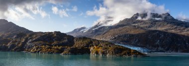 Okyanus kıyısındaki Amerikan Dağ Manzarası 'ndaki Tidewater Buzulu' nun güzel Panoramik Manzarası. Sonbahar sezonunun bulutlu bir sabahında. Buzul Körfezi Ulusal Parkı ve Koruma Alanı, Alaska, Usa.