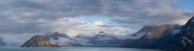 Okyanus kıyısındaki Amerikan Dağ Manzarası 'nın güzel panoramik manzarası. Sonbahar sezonunun bulutlu ve renkli sabahında. Buzul Körfezi Ulusal Parkı ve Koruma Alanı, Alaska, Usa.