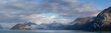 Okyanus kıyısındaki Amerikan Dağ Manzarası 'nın güzel panoramik manzarası. Sonbahar sezonunun bulutlu ve renkli sabahında. Buzul Körfezi Ulusal Parkı ve Koruma Alanı, Alaska, Usa.