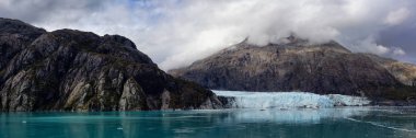 Margerie Buzulu 'nun güzel Panoramik Manzarası. Okyanus kıyısındaki Amerikan Dağ Manzarası. Sonbahar sezonunun bulutlu bir sabahı. Buzul Körfezi Ulusal Parkı ve Koruma Alanı, Alaska, Usa.