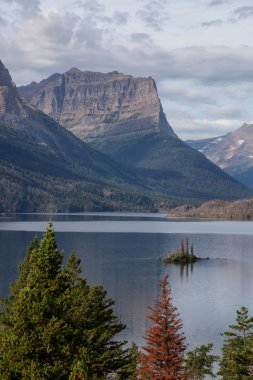 Bulutlu bir yaz sabahı boyunca arka planda Amerikan Rocky Dağı manzaralı güzel bir Buzul Gölü Manzarası. Buzul Ulusal Parkı, Montana, ABD 'de çekildi..