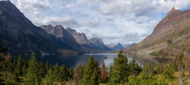 Güzel bir Buzul Gölü Panoramik Manzarası. Arka planda Amerikan Rocky Dağı manzarası var. Bulutlu bir yaz sabahı sırasında. Buzul Ulusal Parkı, Montana, ABD 'de çekildi..