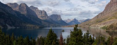 Güzel bir Buzul Gölü Panoramik Manzarası. Arka planda Amerikan Rocky Dağı manzarası var. Bulutlu bir yaz sabahı sırasında. Buzul Ulusal Parkı, Montana, ABD 'de çekildi..