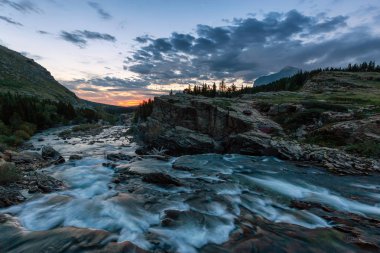 Amerikan Kayalıkları 'nda bulutlu bir sabah güneşinde Buzul Nehri' nin güzel manzarası. Swiftcurrent Gölü, Buzul Ulusal Parkı, Montana, ABD.