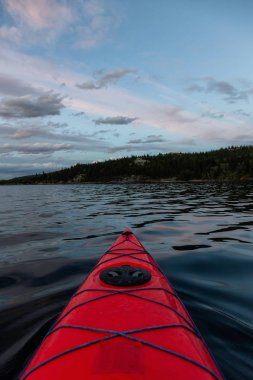 Buzul Gölü 'nde kayak yaparken bulutlu bir yaz günbatımında güzel Kanada Rocky Dağları etrafını sarmıştı. Yukarı Waterton Gölü, Alberta, Kanada.