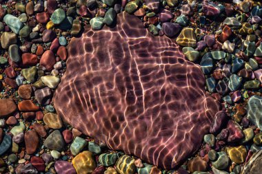 Güneşli bir yaz gününde, Buzul Gölü 'ndeki renkli kayalar. McDonald Gölü, Buzul Ulusal Parkı, Montana, Usa 'da çekildi..