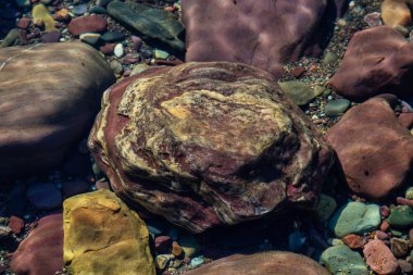 Güneşli bir yaz gününde, Buzul Gölü 'ndeki renkli kayalar. McDonald Gölü, Buzul Ulusal Parkı, Montana, Usa 'da çekildi..