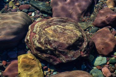 Güneşli bir yaz gününde, Buzul Gölü 'ndeki renkli kayalar. McDonald Gölü, Buzul Ulusal Parkı, Montana, Usa 'da çekildi..