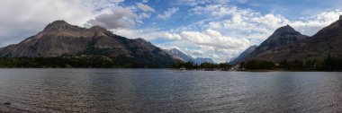 Yukarı Waterton Gölü, Alberta, Kanada - 31 Ağustos 2019: Kanada 'nın bulutlu yaz günbatımında güzel Kanada Rocky Dağları ile çevrili Buzul Gölü Panoramik Manzarası.