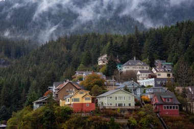 Fırtınalı ve yağmurlu bir sabahta, okyanus kıyısındaki küçük bir turistik kasabadaki tepenin üzerindeki yerleşim yerlerinin güzel hava manzarası. Ketchikan, Alaska, ABD 'de çekildi.