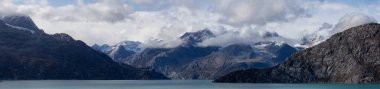 Okyanus kıyısındaki Amerikan Dağ Manzarası 'nın güzel panoramik manzarası. Sonbahar sezonunun bulutlu ve renkli sabahında. Buzul Körfezi Ulusal Parkı ve Koruma Alanı, Alaska, Usa.