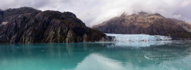 Margerie Buzulu 'nun güzel Panoramik Manzarası. Okyanus kıyısındaki Amerikan Dağ Manzarası. Sonbahar sezonunun bulutlu bir sabahı. Buzul Körfezi Ulusal Parkı ve Koruma Alanı, Alaska, Usa.