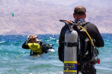 Eilat, İsrail - 12 Nisan 2019: Scuba dalgıcı güneşli bir sabah boyunca Kızıl Deniz 'de dalmaya hazırlanıyor.