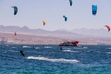 Eilat, İsrail - 12 Nisan 2019: Maceraperest insanlar güneşli bir günde Kızıl Deniz 'de su sporları ve uçurtmanın tadını çıkarıyorlar.