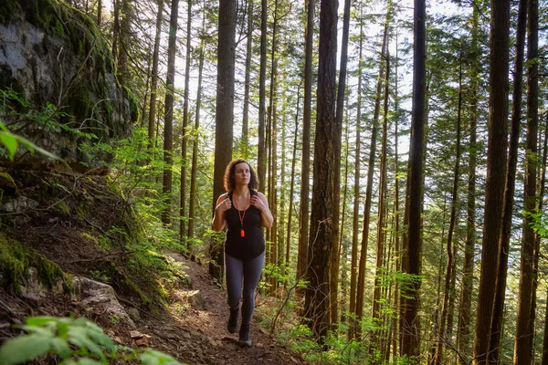 Chica aventurera caminando en un bosque lluvioso verde y vibrante —  Fotos de Stock