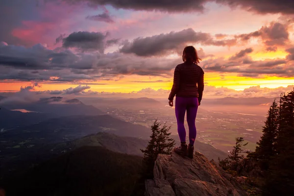 Äventyrlig flicka på toppen av ett stenigt berg med utsikt över den vackra kanadensiska naturen — Stockfoto