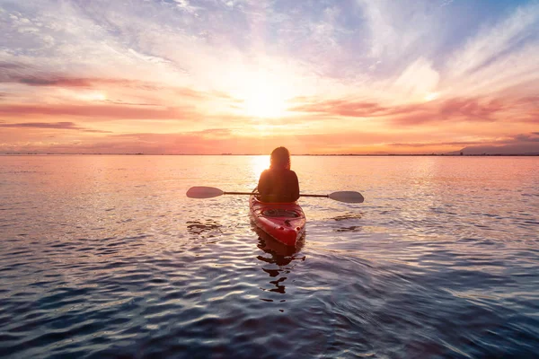 Sea Kayaking in calm waters during a colorful and vibrant sunset.