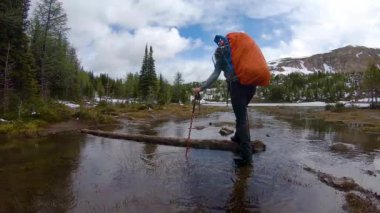 Bulutlu bir günde Kanada Kayalıklarında Kadın Sırt Çantası Yürüyüşü