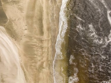 Okyanustan gelen dalgalarla kumsal manzarası..