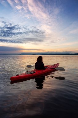 Renkli bir günbatımında kanoya binmek