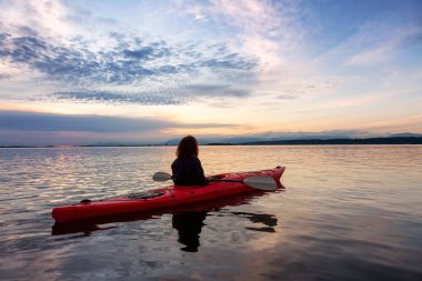 Renkli bir günbatımında kanoya binmek