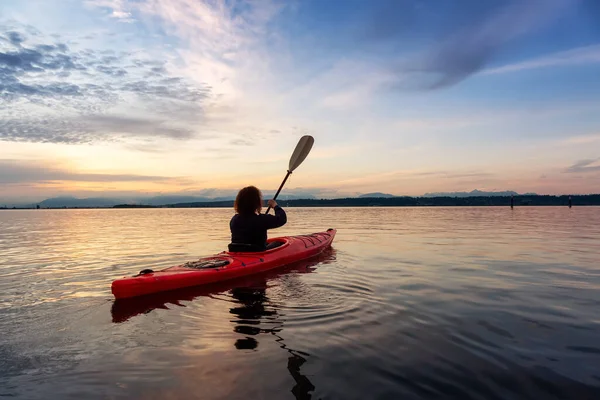 Renkli bir günbatımında kanoya binmek