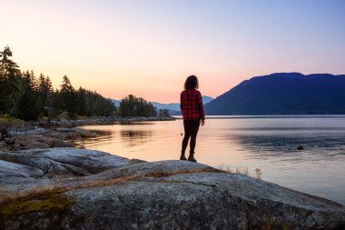 Okyanus kıyısında Huzurlu Gündoğumunu İzleyen Kız