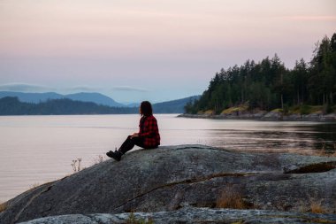 Okyanus kıyısında Huzurlu Gündoğumunu İzleyen Kız