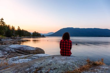Okyanus kıyısında Huzurlu Gündoğumunu İzleyen Kız