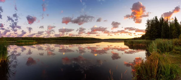 Piękny panoramiczny widok na kolorowy wschód słońca z odbiciem wody nad jeziorem. — Zdjęcie stockowe