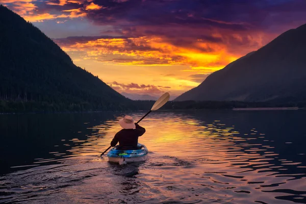 Homem aventureiro caiaque na água rodeado por montanhas — Fotografia de Stock