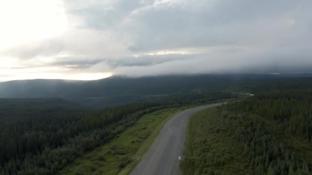 Hermosa vista de la carretera escénica desde arriba rodeado de exuberante bosque, nubes y montañas — Vídeos de Stock